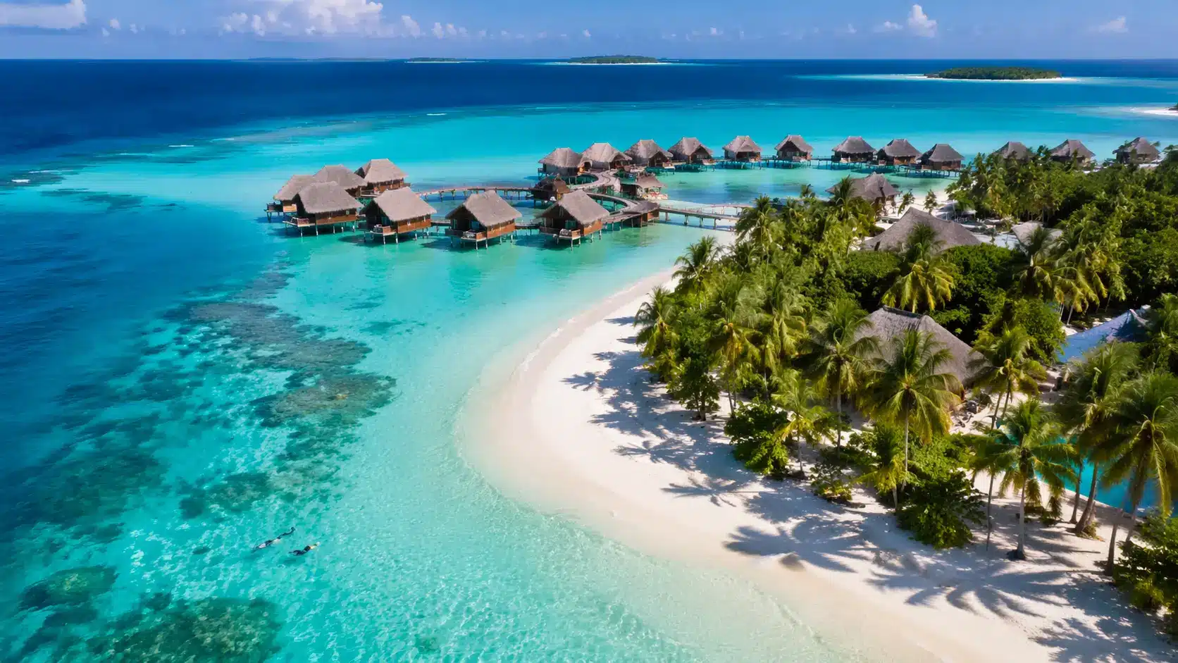 A breathtaking aerial view of a tropical island with overwater bungalows, crystal-clear turquoise waters, and lush palm trees.