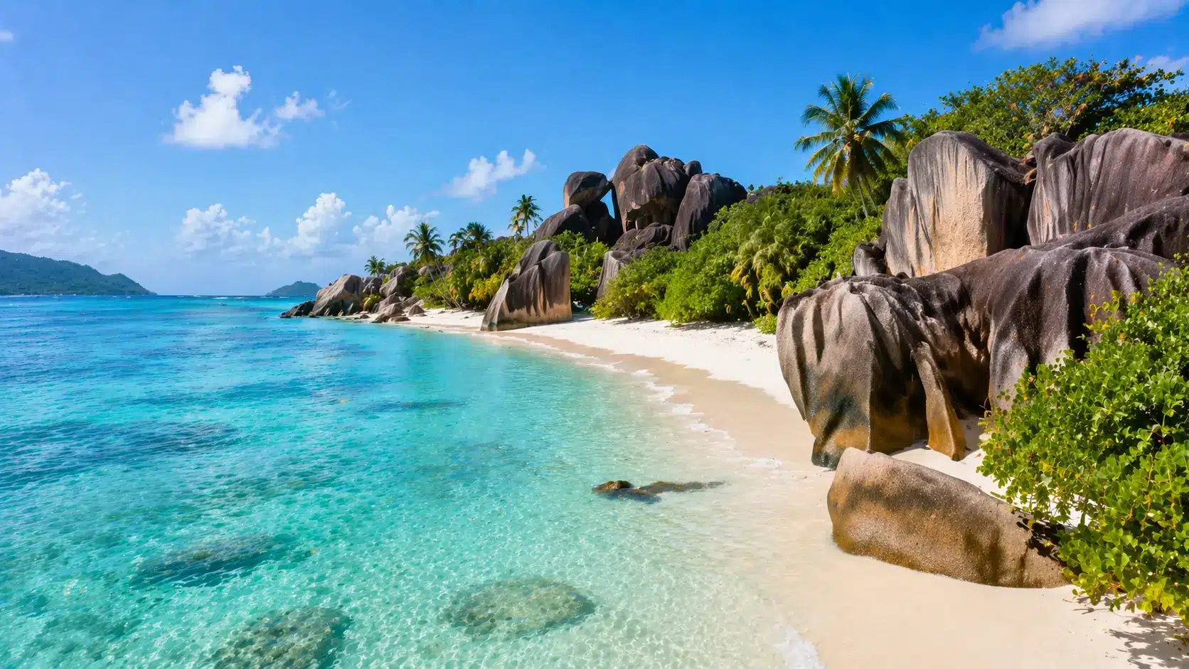 Beach scene in the Seychelles and dramatic granite boulders along the shoreline.