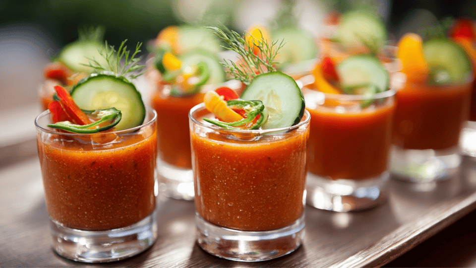 Chilled gazpacho shooters with cucumber and olive oil, arranged for a summer wedding cocktail hour.