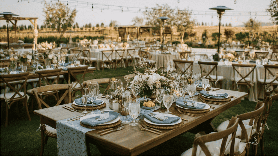 Mediterranean wedding with blue and white decor, lemon centerpieces, olive branches, and rustic dining tables.