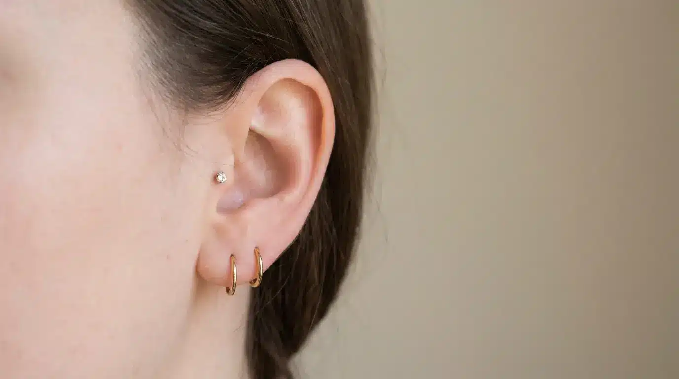 Small ear with delicate lobe and tragus piercings