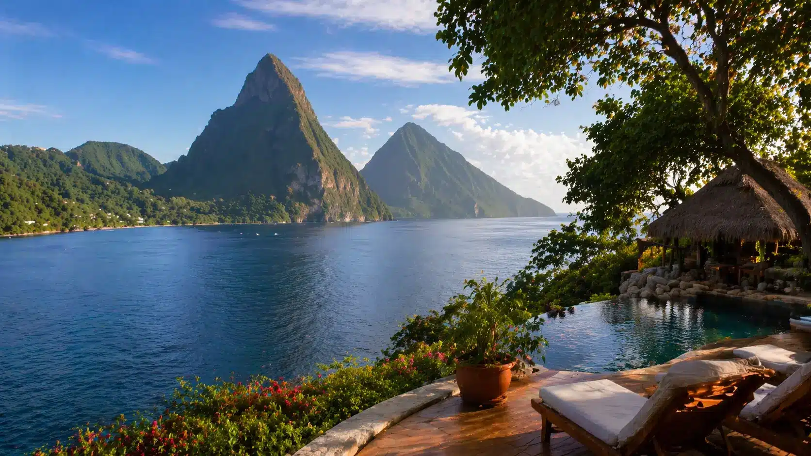 Tropical resort with an infinity pool overlooking the ocean and volcanic peaks, framed by lush greenery