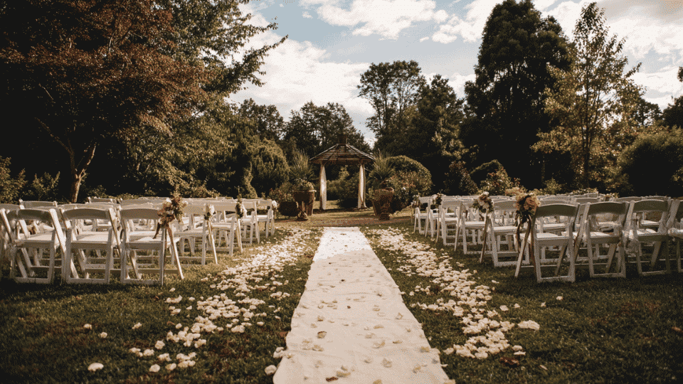 Wedding aisle with white fabric runner, flower petals and ceremony chairs