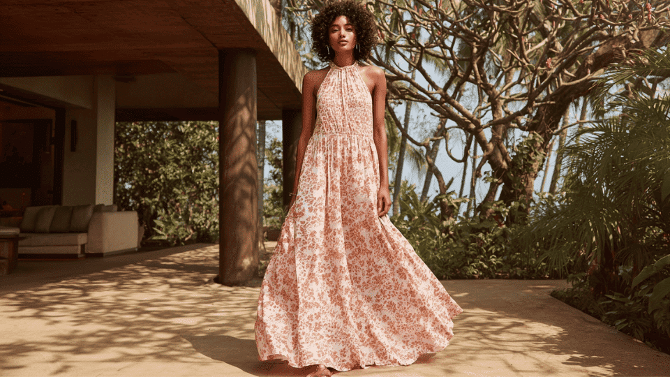 Woman in cotton A-line maxi dress with block print, full length visible in a relaxed outdoor setting.