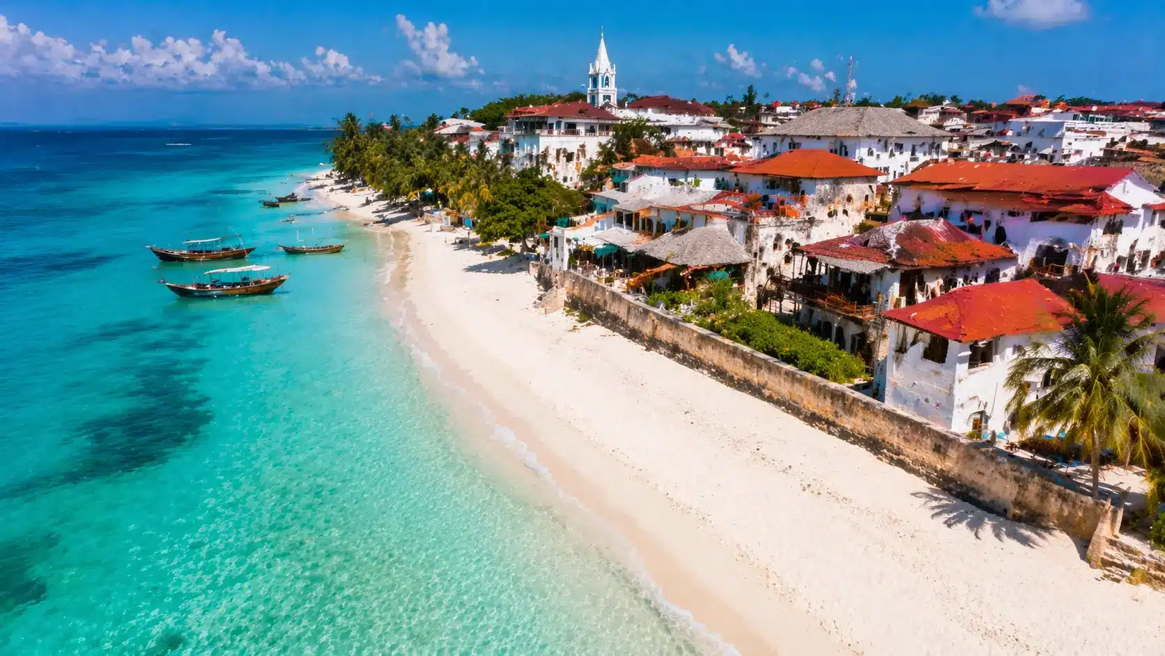 Zanzibar's coastline with traditional wooden boats, white sandy beaches, and historic whitewashed buildings