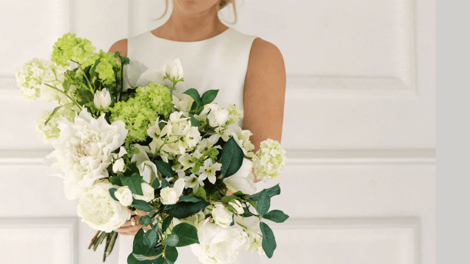 a bride holding flower bouquet by afloral