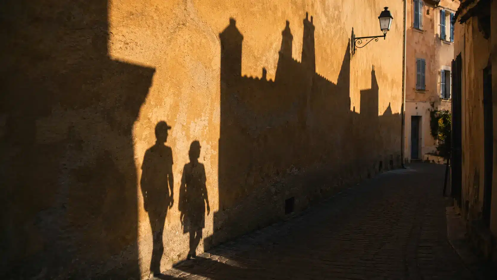 Strong shadows creating artistic patterns on a street wall