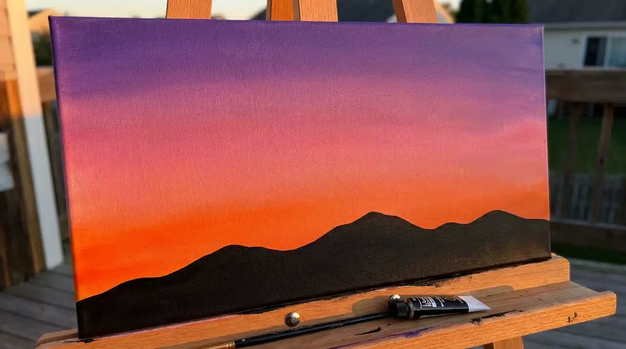 Canvas painted with warm orange, pink, and purple gradient resembling sunset.