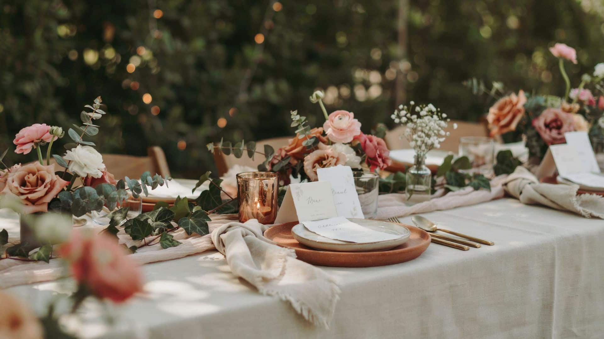 Boho wedding reception table decorated with pampas grass, dried flowers, candles, and warm neutral color accents