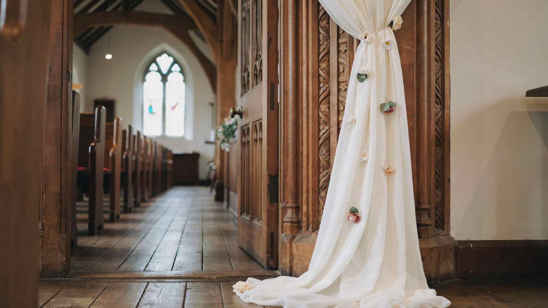 Lightweight fabric draping with floral clips at a church entrance