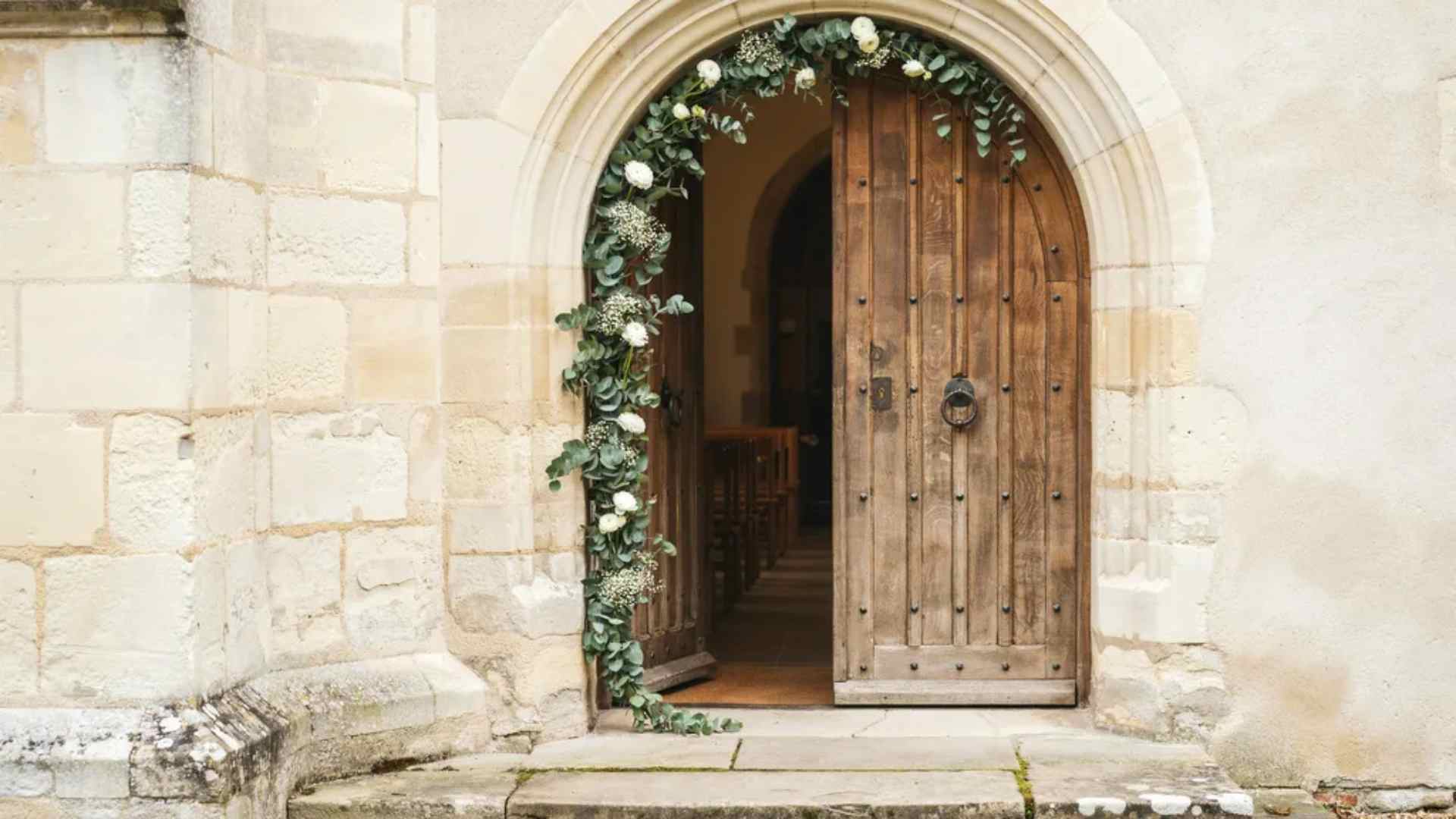 Partial greenery garland decorating a church wedding doorway