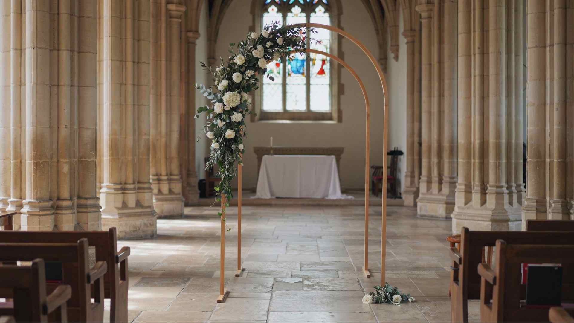 Simple partially decorated floral arch at a church wedding altar