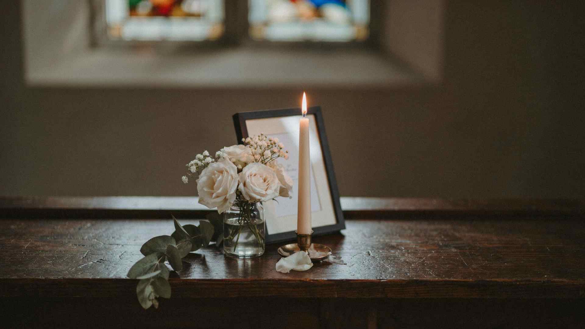 Small memorial flower arrangement in a church wedding setting