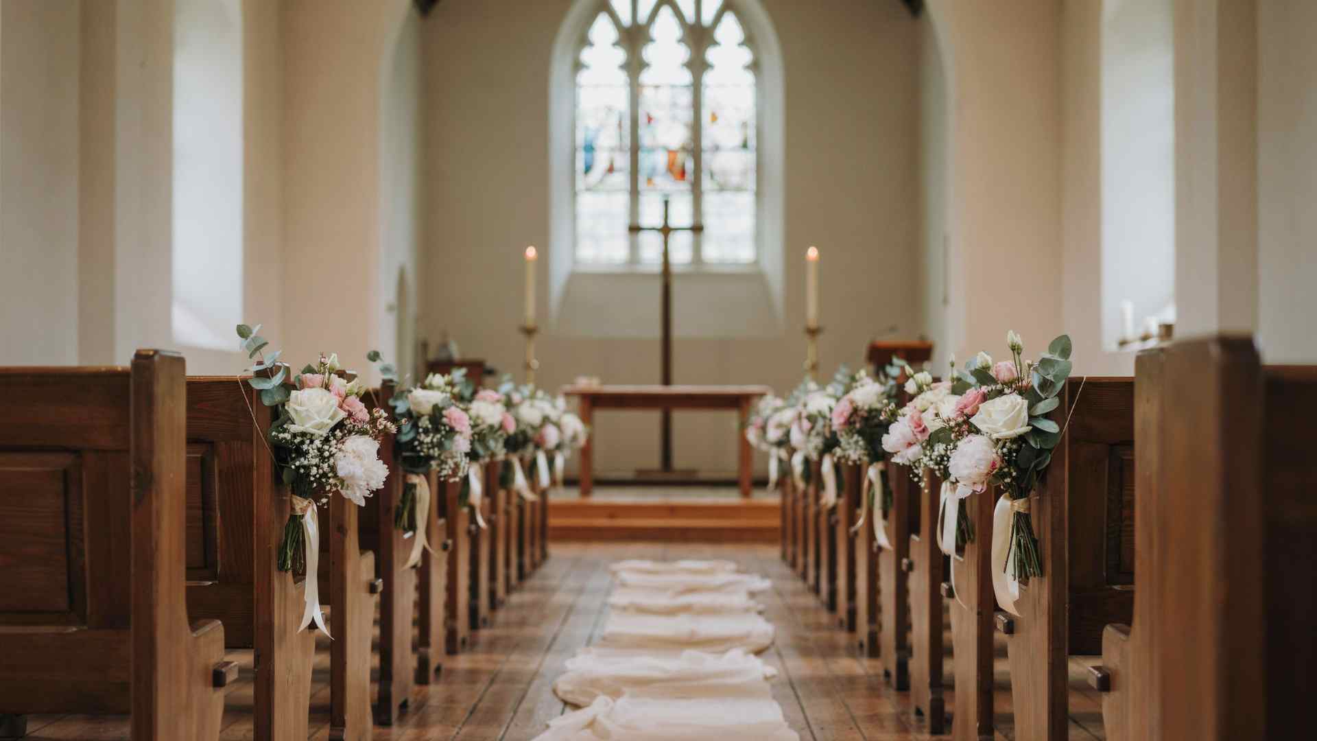 Small mixed flower posies decorating church wedding pews