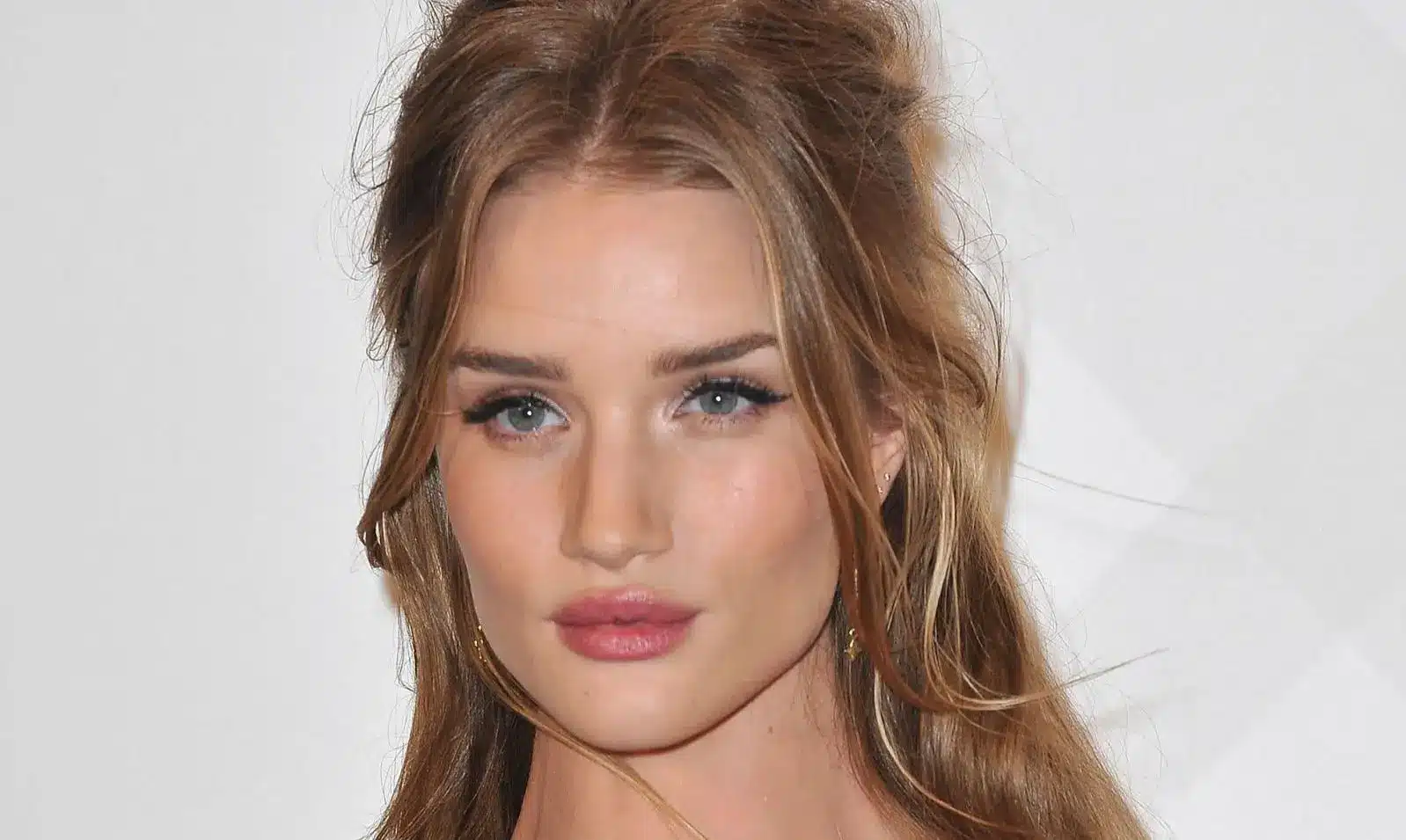 Three quarter bridal view with a half up style and soft face framing pieces beside loose waves in natural daylight