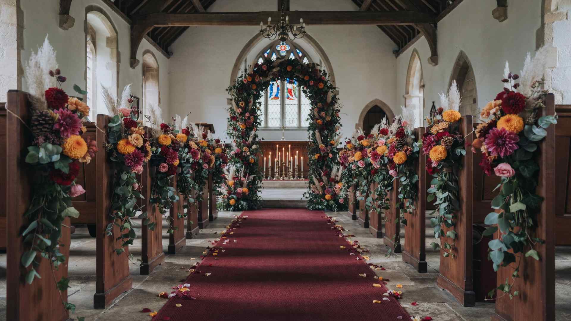 Warm fall flowers and dried elements decorating a church wedding