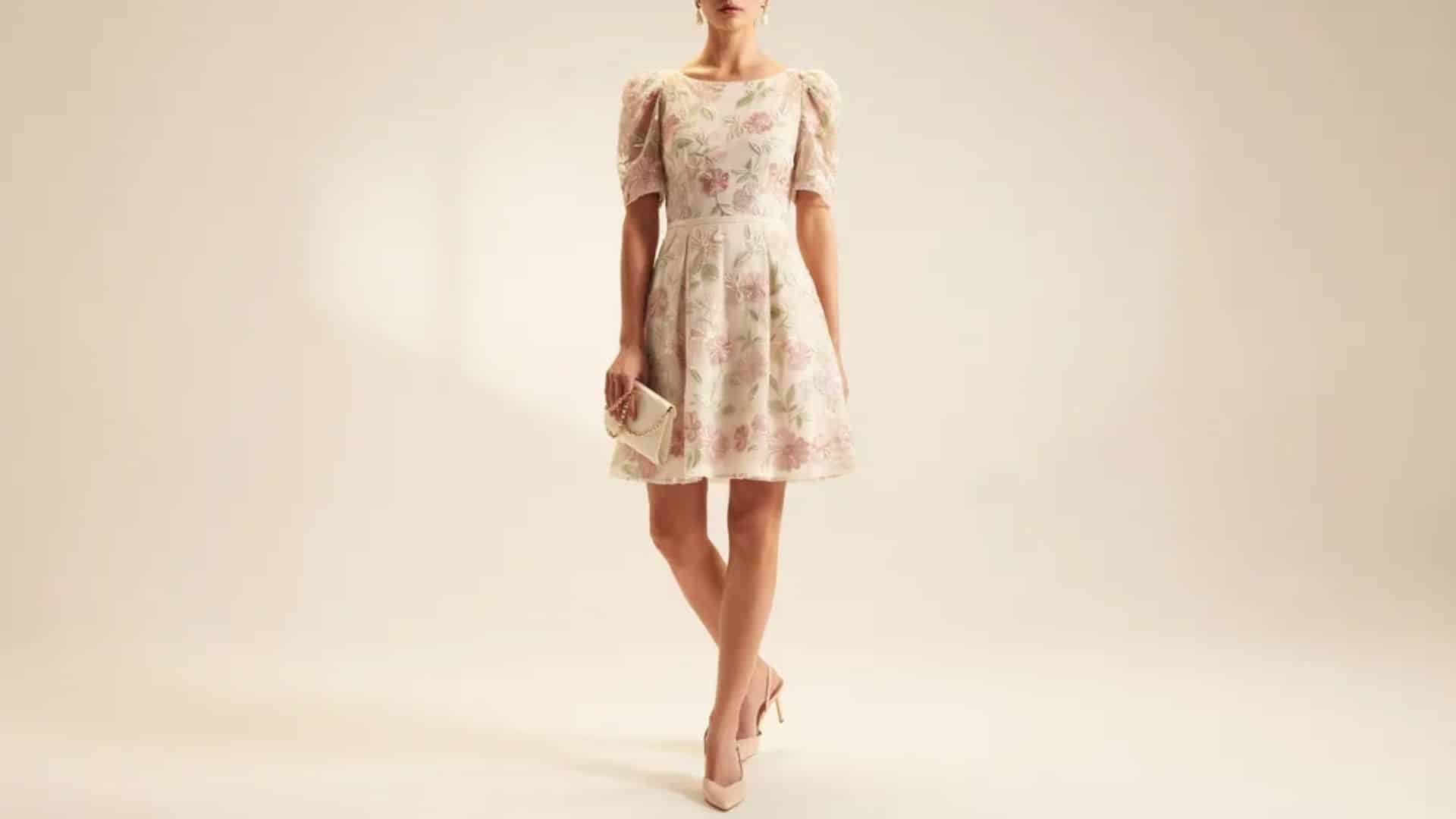 Woman wearing a pastel floral mini dress with puff sleeves and delicate details for a garden wedding outfit